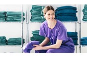 female nurse wearing Barrier a scrub suit sitting in a changing room