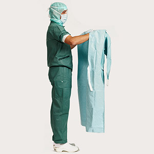 Healthcare professional demonstrating second step of donning a gown
