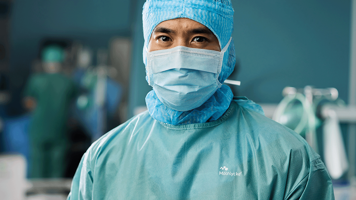 A person wearing a surgical gown and mask. Photo. 
