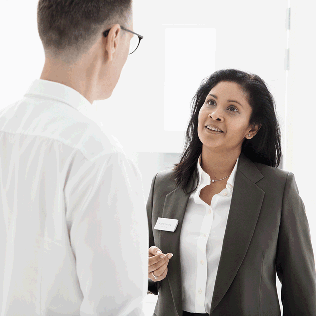 A photo of two office workers talking.