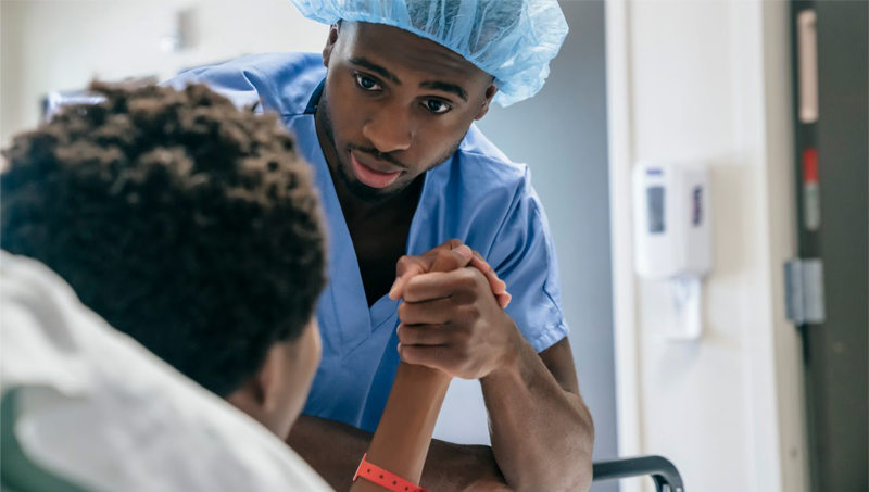 Health care professional holding patient's hand